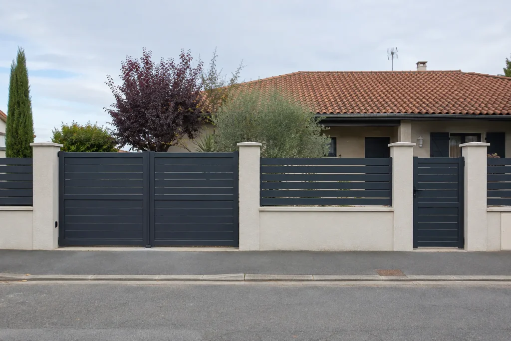 Clôture et portails anthracite sur un soubassement maçonné en bord de rue, illustration d’un projet fictif.