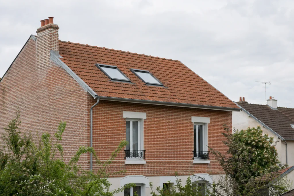 Deux fenêtres de toit intégrées à une toiture en tuiles, illustration d’un projet fictif.